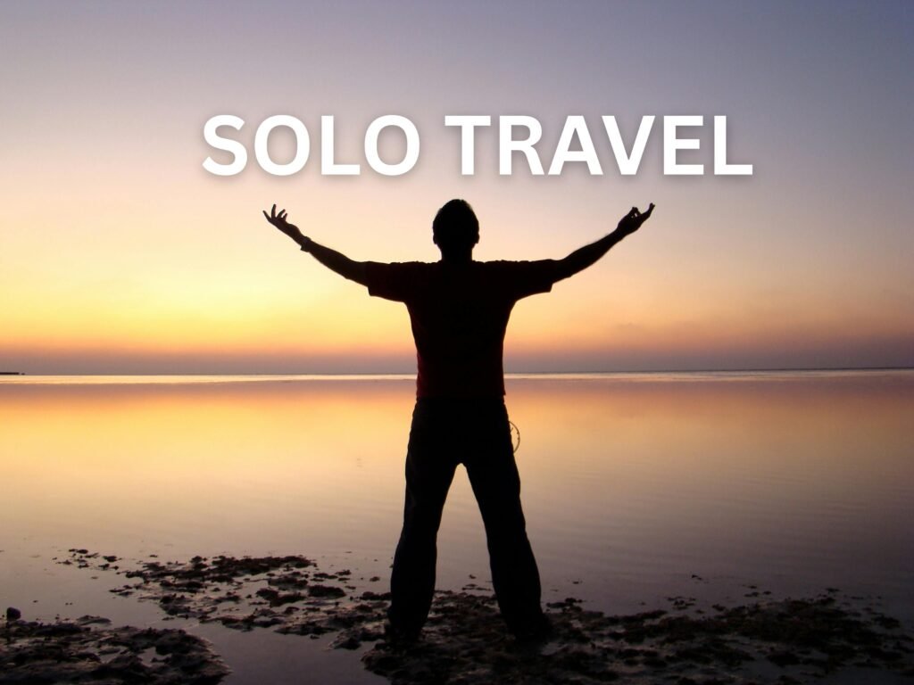 Person enjoying freedom during solo travel at sunset near the ocean