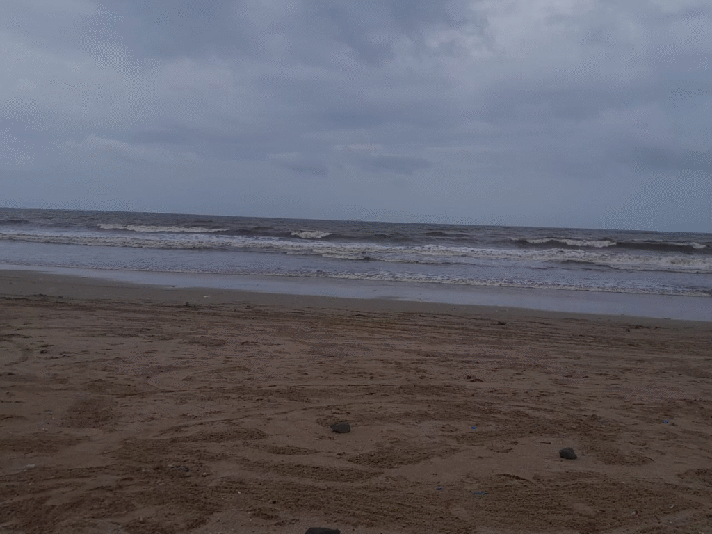 Sandy Alibaug beach during monsoon with cloudy skies, gentle waves, and empty shoreline perfect for a peaceful getaway.