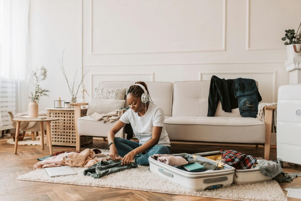 Woman packing suitcase for solo travel while listening to music