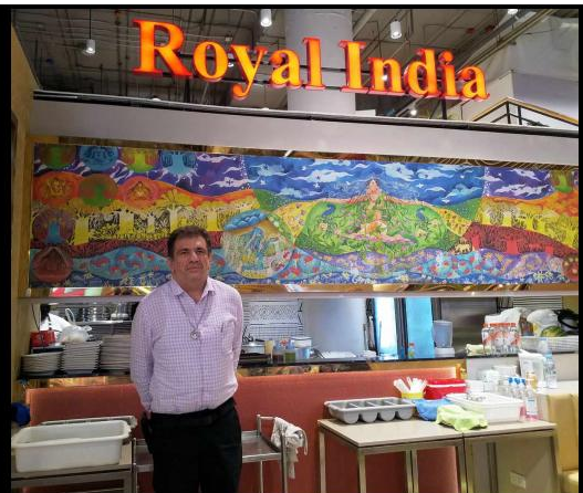A man standing in front of Royal India Restaurant in Bangkok's Little India, known for serving authentic Indian food in Thailand